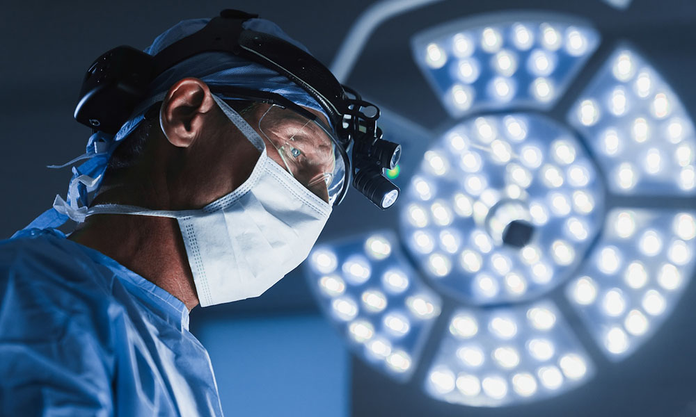 Banner showing surgeon in mask with light behind him